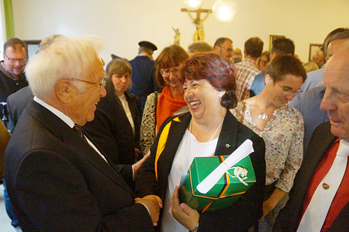 Frau Reinl gratuliert Pfarrer Josef Bock und überreicht ein Geschenk