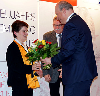 Bürgermeister Christian Kiendl überreicht einen Blumenstrauß an Anne Sedlmeier und Max Höglmeier