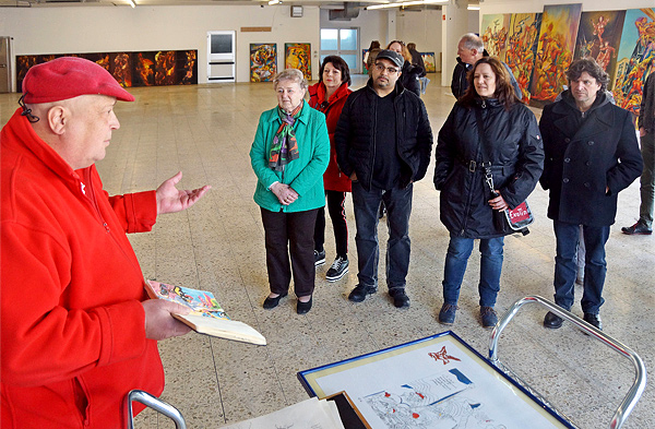 Foto: Der Künstlers erläutert einer Gruppe von Besuchern seine Kunstwerke