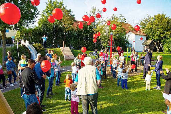 Foto der Kinder, die rote Luftballon steigen lassen