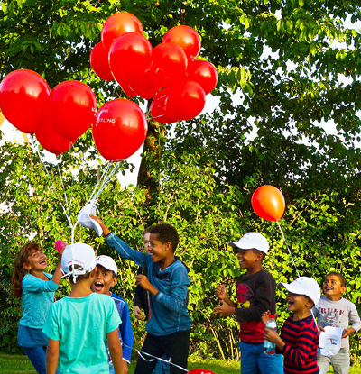 Gruppe von Kindern mit roten Luftballons