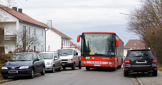 Foto eines Busses, der sich zwischen parkenden Autos hindurchzwngt