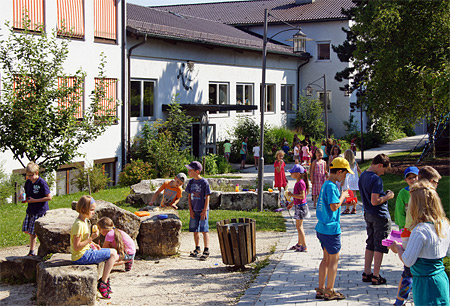Foto Pausenhof mit Schulhaus-Fenster und Rollos im Hintergrund